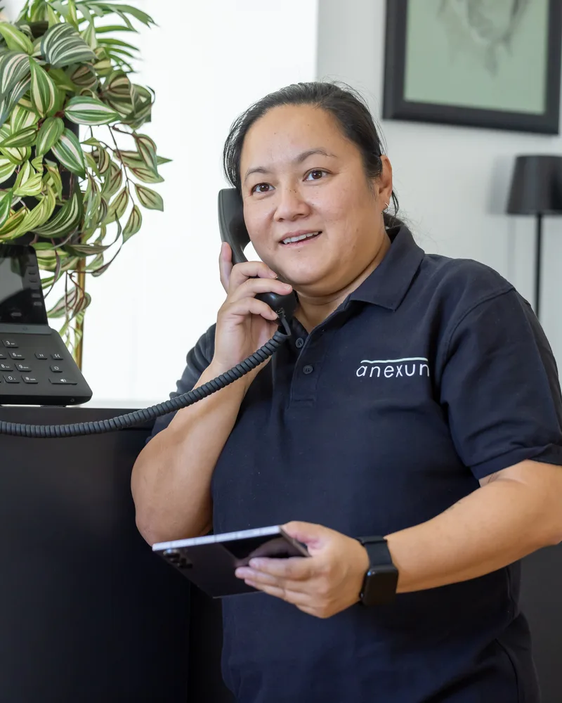 Mitarbeiterin von Anexum im Telefongespräch am Arbeitsplatz